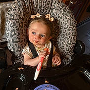 Isla-Robyn joined the competition — help win amazing prizes! toddler, child, high_chair, spoon, food, messy, plate, leopard_print, bow, hair, blue_eyes, indoor, kitchen, seatbelt, feeding, cute, expression, small_hand, table, baby_food