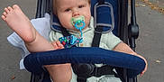Louis joined the competition — help win amazing prizes! baby, stroller, pacifier, foot, outdoor, sidewalk, child, blue, clothing, seatbelt, toy, expression, person, infant, park, daytime, relaxing, cute, casual, transport