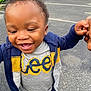 asphalt, casual_clothing, child, curly_hair, cute, daytime, footwear, happy, holding_hand, jacket, joyful, lee_tshirt, outdoor, parking_lot, person, smiling, toddler, urban, walking, white_car