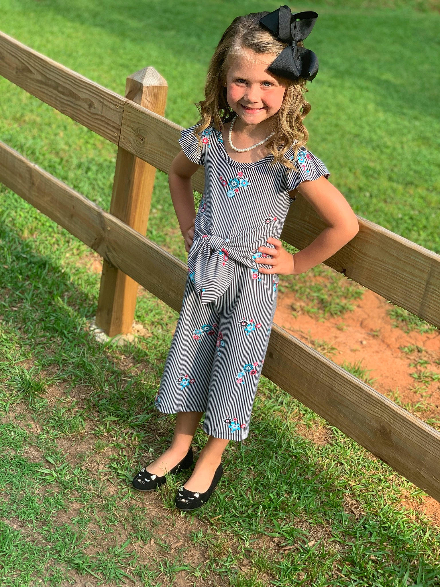 Rilynn is registered to the contest to win money with this photo: child, clothing, denim, design, dress, fence, footwear, fun, grass, jeans, joy, overall, pattern, person, plaid, shoe, sleeve, smile, summer, vacation