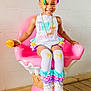 child, girl, smiling, hair_clips, colorful, white_shoes, knee_high_socks, bracelets, necklace, pink_chair, ice_cream_chair, wooden_floor, pastel_colors, happy, indoor, toy, cute, playful, fashion, portrait