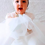 Mia participe au concours pour gagner de l'argent avec cette photo : adorable, baby, celebration, child, childhood, cute, face, fashion, flower, happy, headband, indoor, infant, person, portrait, smiling, soft_light, tulle, white_dress, young