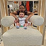 Jordan joined the competition — help win amazing prizes! baby, woman, armchair, smile, clothing, store, furniture, happy, indoor, person, baby_clothes, textile, wood, socks, pacifier, background, pattern, sitting, holding, joy