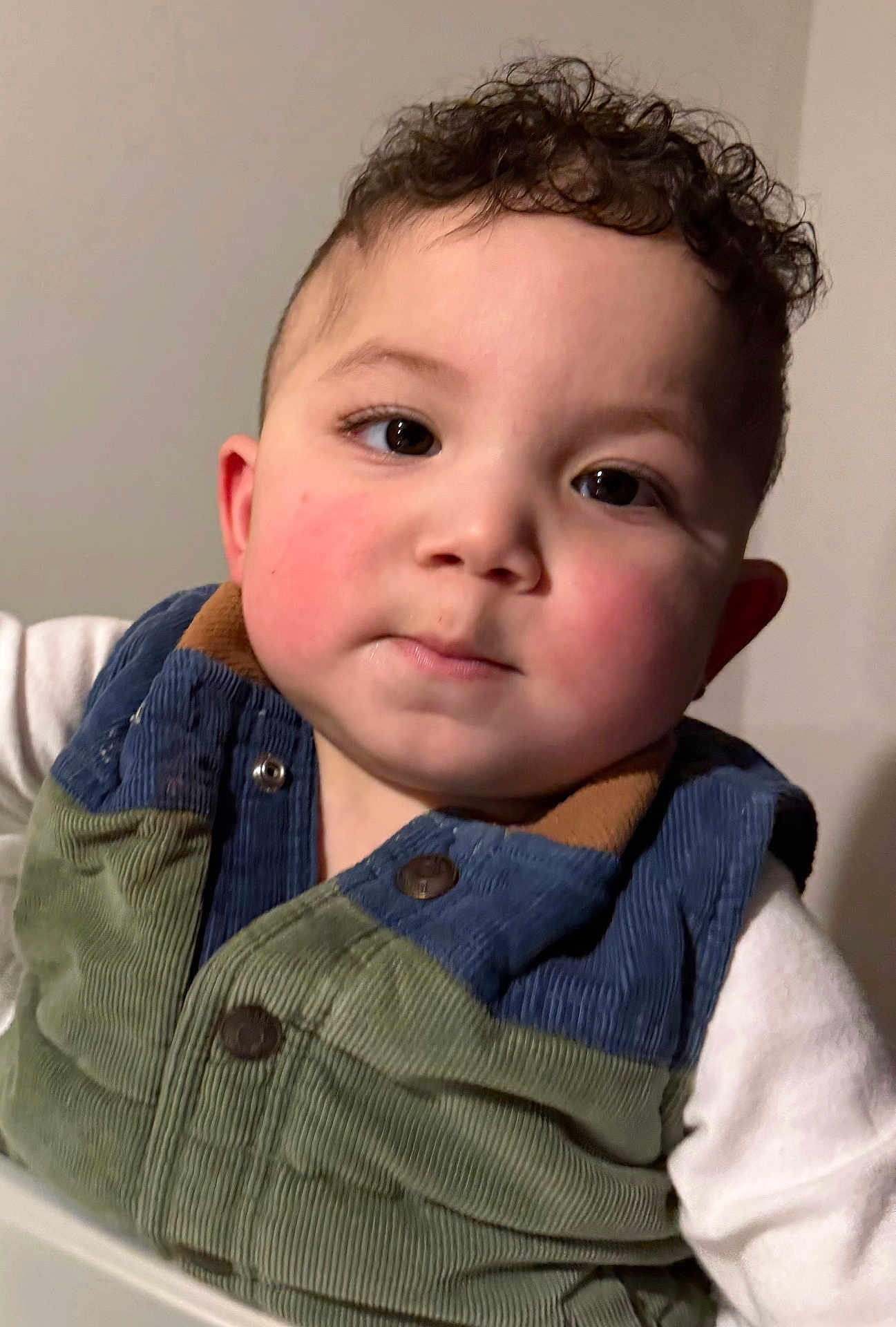 Theo is registered to the contest to win money with this photo: toddler, child, face, curly_hair, rosy_cheeks, vest, clothing, portrait, indoor, person, baby, cute, young_child, expression, head_and_shoulders, human, skin, eyebrows, eyes, casual_wear