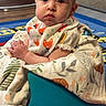 Shayla is registered to the contest to win money with this photo: baby, child, infant, sitting, portrait, face, eyes, wide_eyed, indoors, playroom, blanket, bib, fox_pattern, cushion, rug, colorful, furniture, home, seated, photography