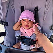 Aylany joined the competition — help win amazing prizes! baby, child, stroller, pink_cap, pink_outfit, hand, finger, safety_strap, seat, happy, tongue_out, infant, cute, person, outdoor, sunlight, smile, clothing, baby_toy, holding