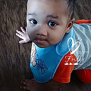 Legend joined the competition — help win amazing prizes! baby, infant, child, crawling, floor, wood_floor, bib, blue_clothing, red_clothing, portrait, face, eyes, wide_eyed, looking_at_camera, indoor, home, hand, smiling, decorative_text, photograph
