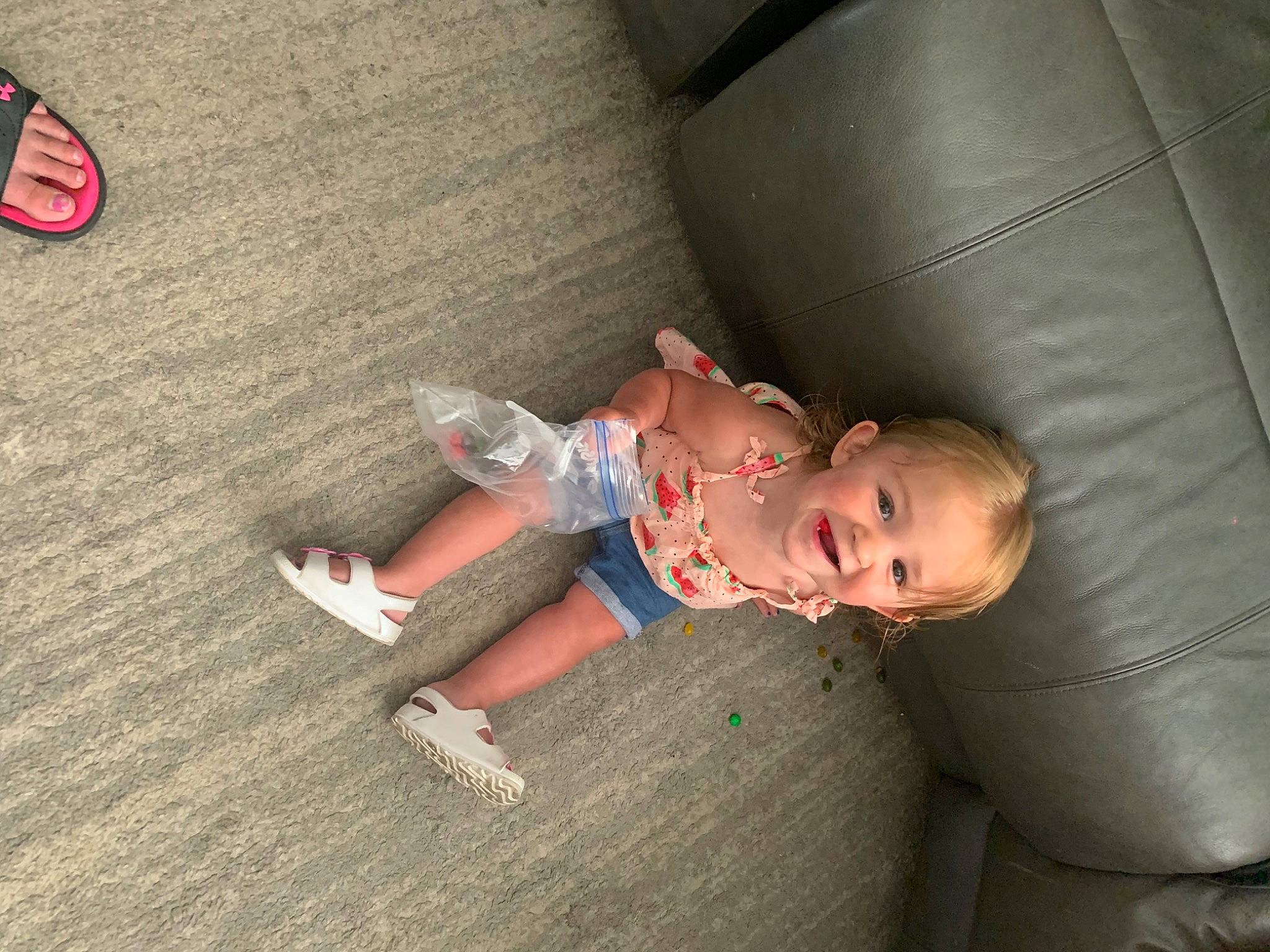 Athena is registered to the contest to win money with this photo: baby, baby_toddler_clothing, child, comfort, finger, floor, flooring, foot, fun, grass, hardwood, human_leg, joy, knee, leg, person, sitting, skin, sneakers, thigh