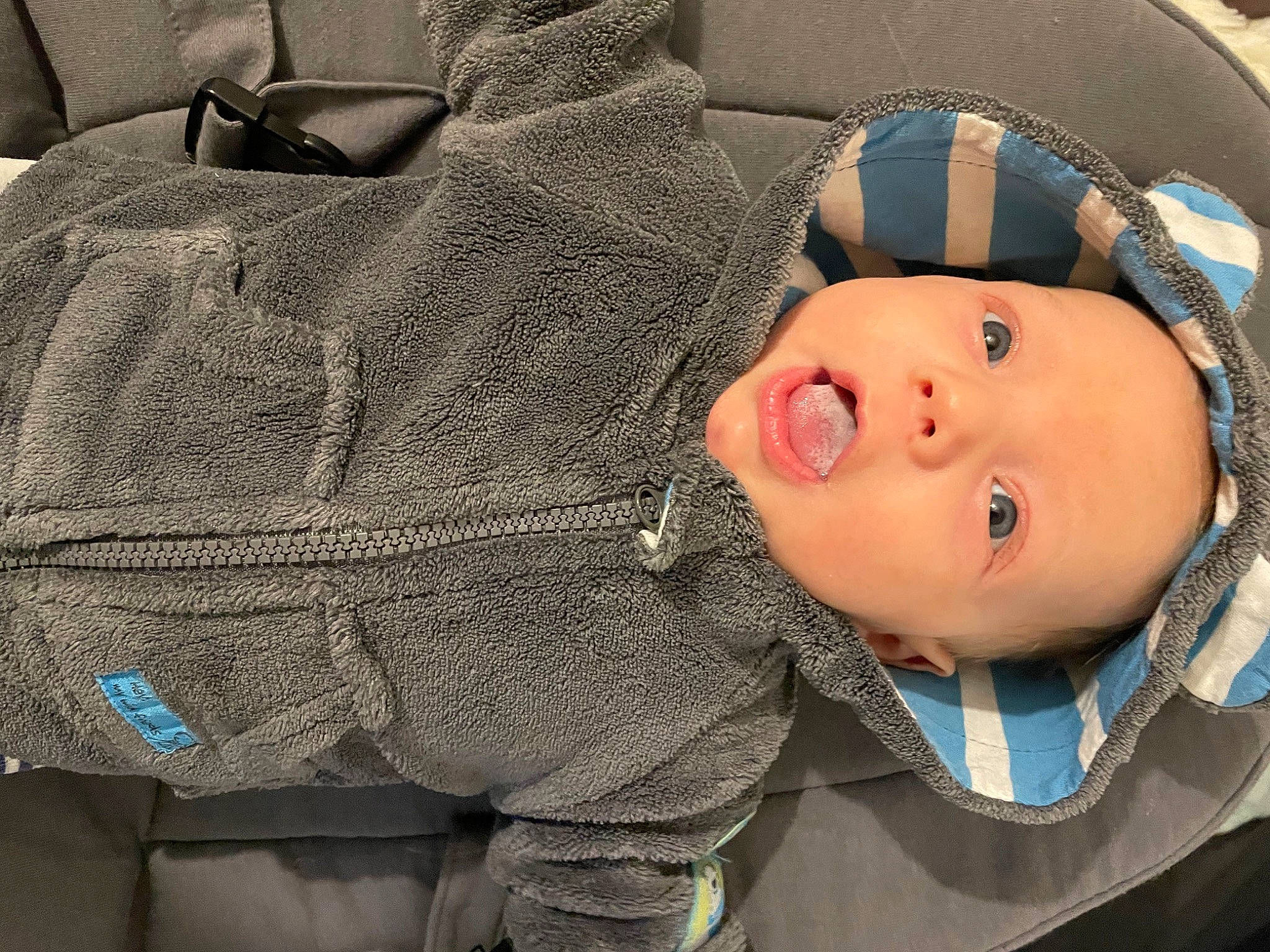 Elyo participe au concours pour gagner de l'argent avec cette photo : baby, baby_products, baby_toddler_clothing, beanie, cap, cheek, child, comfort, denim, electric_blue, eyelash, fashion_accessory, hoodie, jacket, nose, outerwear, person, sitting, sleeve, toddler