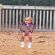 Bryale joined the competition — help win amazing prizes! toddler, child, swing, playground, bucket_swing, wood_chips, wooden_fence, trees, outdoor, smiling, happy, casual_clothing, white_shoes, baby, fun, recreation, daytime, nature, park, person