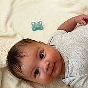 Ethan a rejoint le concours — aidez-le/la à gagner de superbes lots ! baby, infant, pacifier, blanket, clothing, onesie, face, skin, expression, lying_down, soft_texture, indoor, cute, child, newborn, sleepwear, head, smile, portrait, baby_girl_or_boy