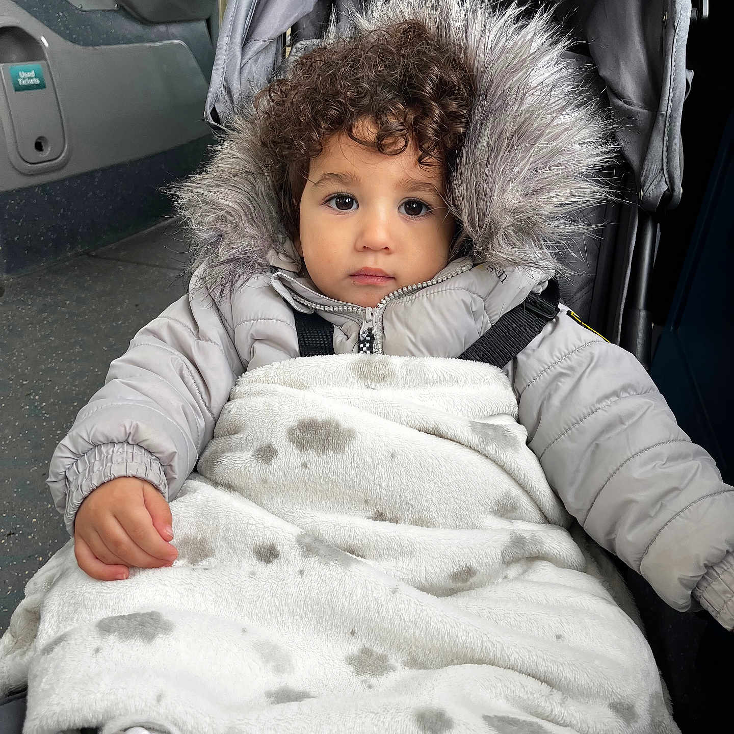Kamari is registered to the contest to win money with this photo: baby, blanket, bodypart, clothing, coat, face, finger, footwear, glove, hand, head, hood, hoodie, jacket, knitwear, person, photography, portrait, shoe, sweater