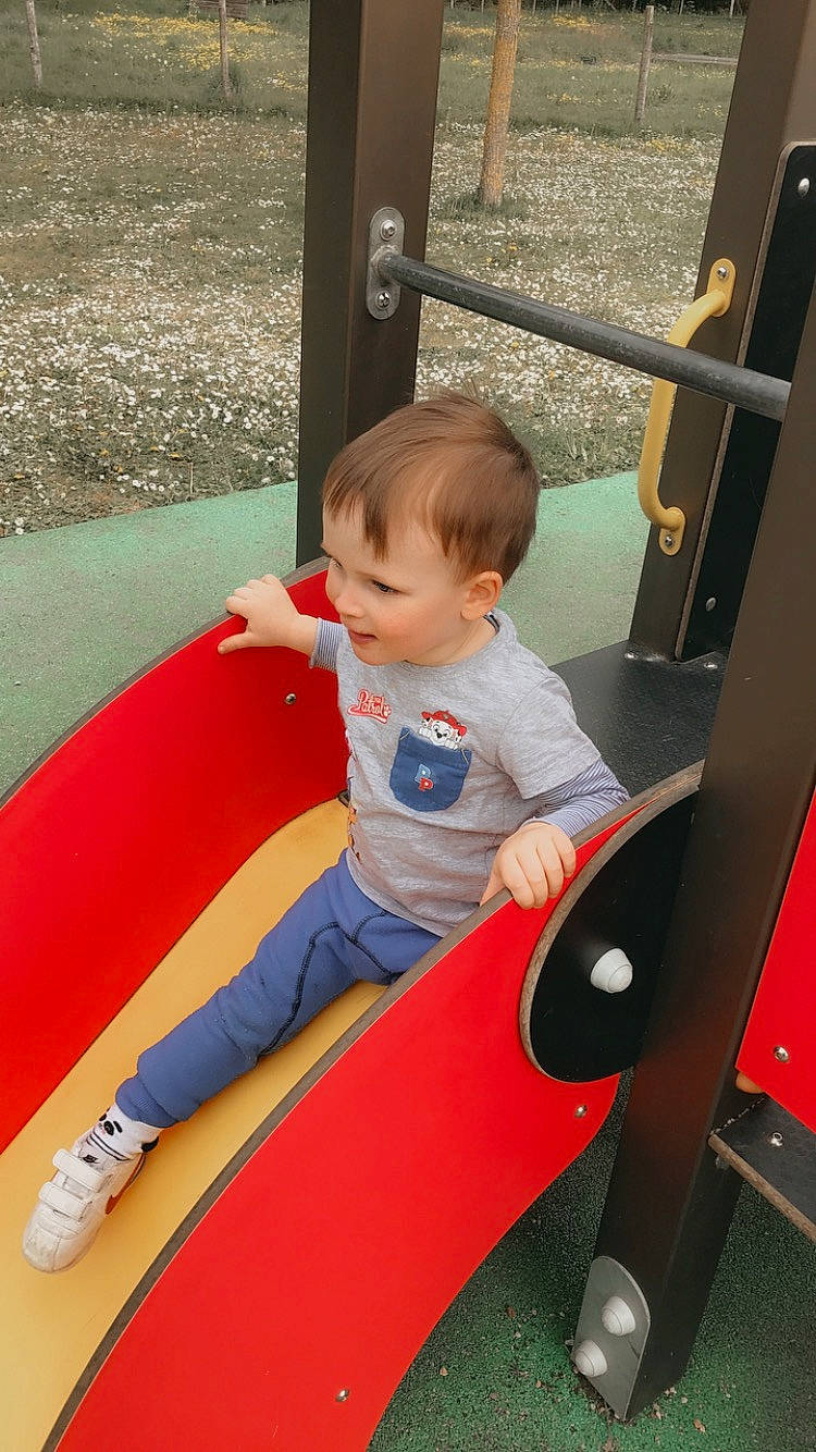 Lyam a rejoint le concours — aidez-le/la à gagner de superbes lots ! automotive_exterior, baby, child, electric_blue, fun, human_leg, human_settlement, leg, leisure, motor_vehicle, person, play, playground, public_space, recreation, sitting, standing, t_shirt, thigh, toddler