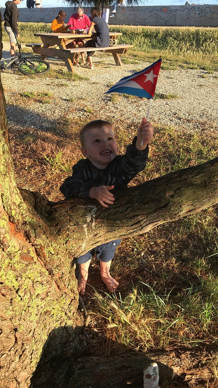 Lyam a rejoint le concours — aidez-le/la à gagner de superbes lots ! child, flag, fun, grass, green, happy, landscape, leaf, leisure, people_in_nature, person, recreation, shadow, sitting, smile, soil, t_shirt, toddler, tree, trunk