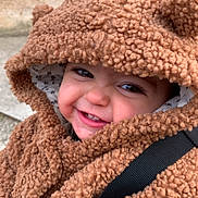 Elena a rejoint le concours — aidez-le/la à gagner de superbes lots ! child, toddler, baby, smile, hood, fuzzy_coat, teddy_texture, closeup, portrait, rosy_cheeks, teeth, stroller_strap, warm_clothing, outdoor, stone_wall, candid, cute, eyes, playful_expression, coat