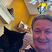 Jade joined the competition — help win amazing prizes! black_cat, cat, ceiling, cozy, decor, face, furniture, home, indoor, lamp, older_adult, pattern, person, photo_frame, portrait, selfie, smile, wall, whiskers, woman