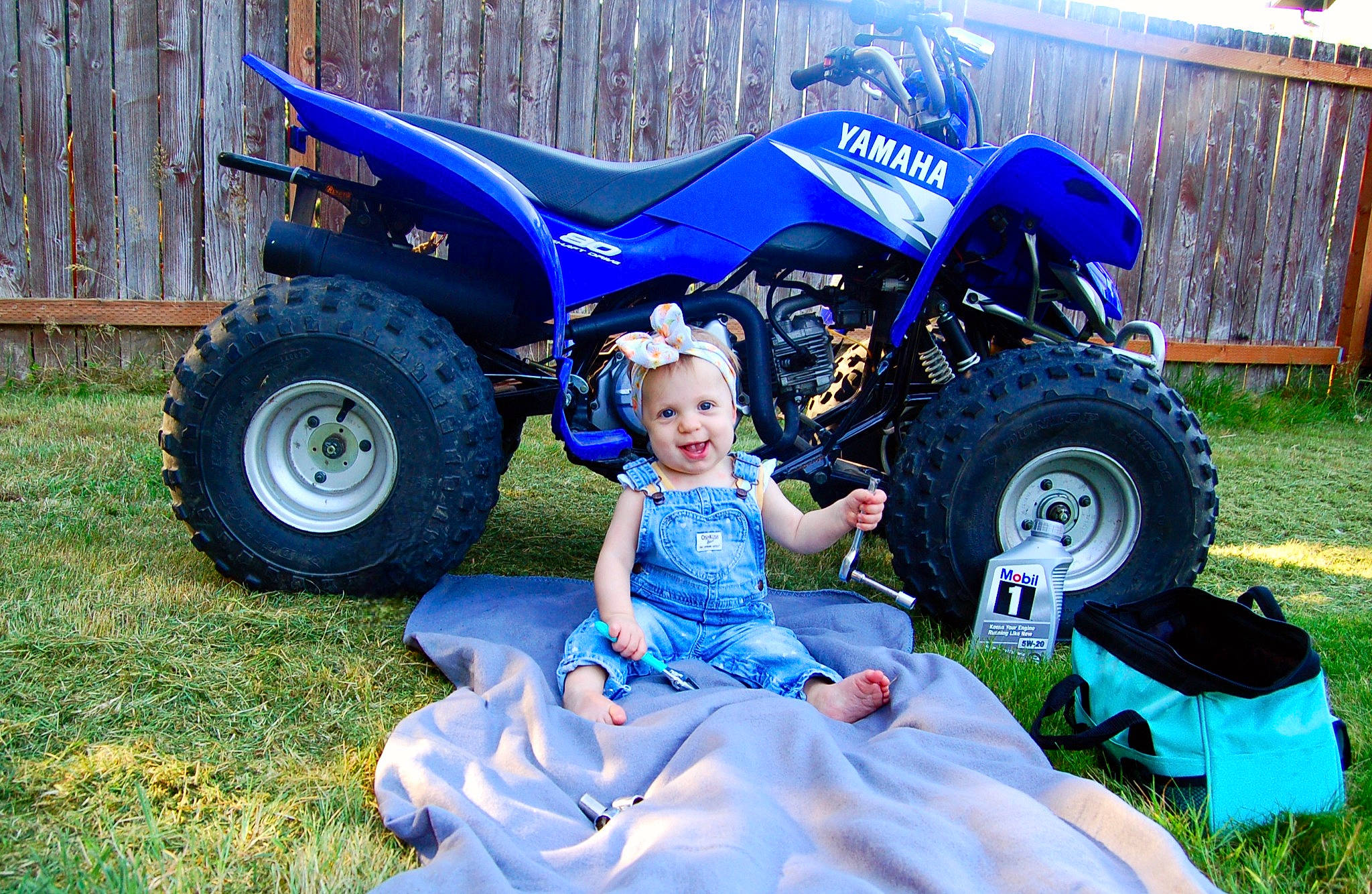 Elliemae joined the competition — help win amazing prizes! agricultural_machinery, automotive_exterior, automotive_tire, automotive_wheel_system, blue, fender, grass, grassland, hat, headwear, land_vehicle, motor_vehicle, person, plant, rural_area, smile, sun_hat, tire, tractor, tread