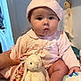 baby, child, infant, pink_clothing, hat, stuffed_animal, bunny_toy, hand, indoor, cute, soft_toy, person, sitting, face, chubby_cheeks, toy, clothing, expressionless, skin, holding