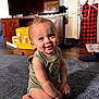Audis joined the competition — help win amazing prizes! baby, child, smiling, indoors, carpet, green_shirt, diaper, hair, mohawk, furniture, television, wooden_cabinet, floor, toy, bracelet, face, happy, person, home, living_room