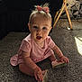 baby, child, pink_dress, bow, carpet, indoor, sitting, shoe, hand, footwear, curious, light, shadow, floor, person, young_child, expression, playful, home, furniture