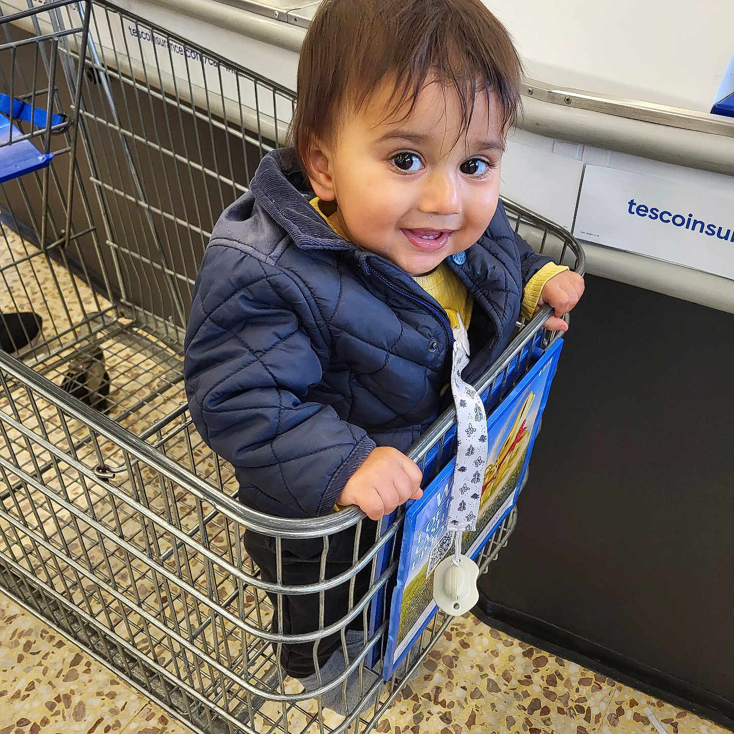 Keeran joined the competition — help win amazing prizes! casual, checkout, child, clothing, face, floor, grocery, handle, happy, holding, indoor, jacket, person, retail, shopping_cart, smiling, store, supermarket, toddler, young_child
