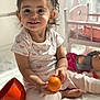Aymila participe au concours pour gagner de l'argent avec cette photo : child, toddler, smiling, pigtails, orange_ball, toy, doll, doll_bed, white_rug, pink_pants, heart_pattern_shirt, earrings, necklace, indoors, sunlight, playtime, cute, happy, baby, floor