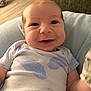 Jasiah joined the competition — help win amazing prizes! baby, smiling, infant, onesie, leaf_pattern, blue, cushion, cozy, indoor, living_room, face, happy, cute, child, person, soft, comfort, closeup, head, skin