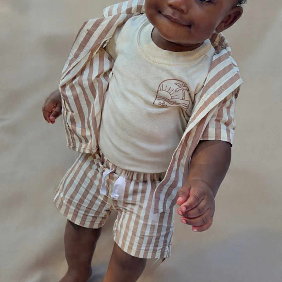 Marquin is registered to the contest to win money with this photo: toddler, child, standing, striped_shirt, striped_shorts, barefoot, curly_hair, smiling, cute, portrait, neutral_background, clothing, young_child, person, indoors, fashion, casual, happy, baby, innocent