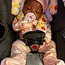 baby, baby_carrier, car_seat, close_up, colorful, cozy, floral_clothing, harness, indoors, infant, mittens, onesie, pacifier, pink_hat, portrait, rainbow_pattern, resting, safe_travel, seat_belt, sleeping