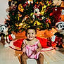 baby, child, christmas_tree, pink_clothing, mickey_mouse, minnie_mouse, plush_toys, holiday_decor, smiling, clapping, indoors, festive, floor, toy, celebration, cute, happy, toddler, decoration, holiday_lights