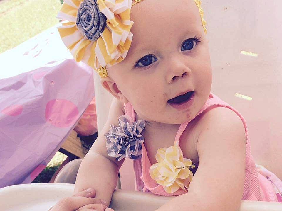 Caitlyn is registered to the contest to win money with this photo: baby, beauty, birthday, cheek, child, dress, face, facial_expression, fashion_accessory, flower, hair_accessory, happy, headband, headgear, headpiece, person, pink, skin, smile, toddler