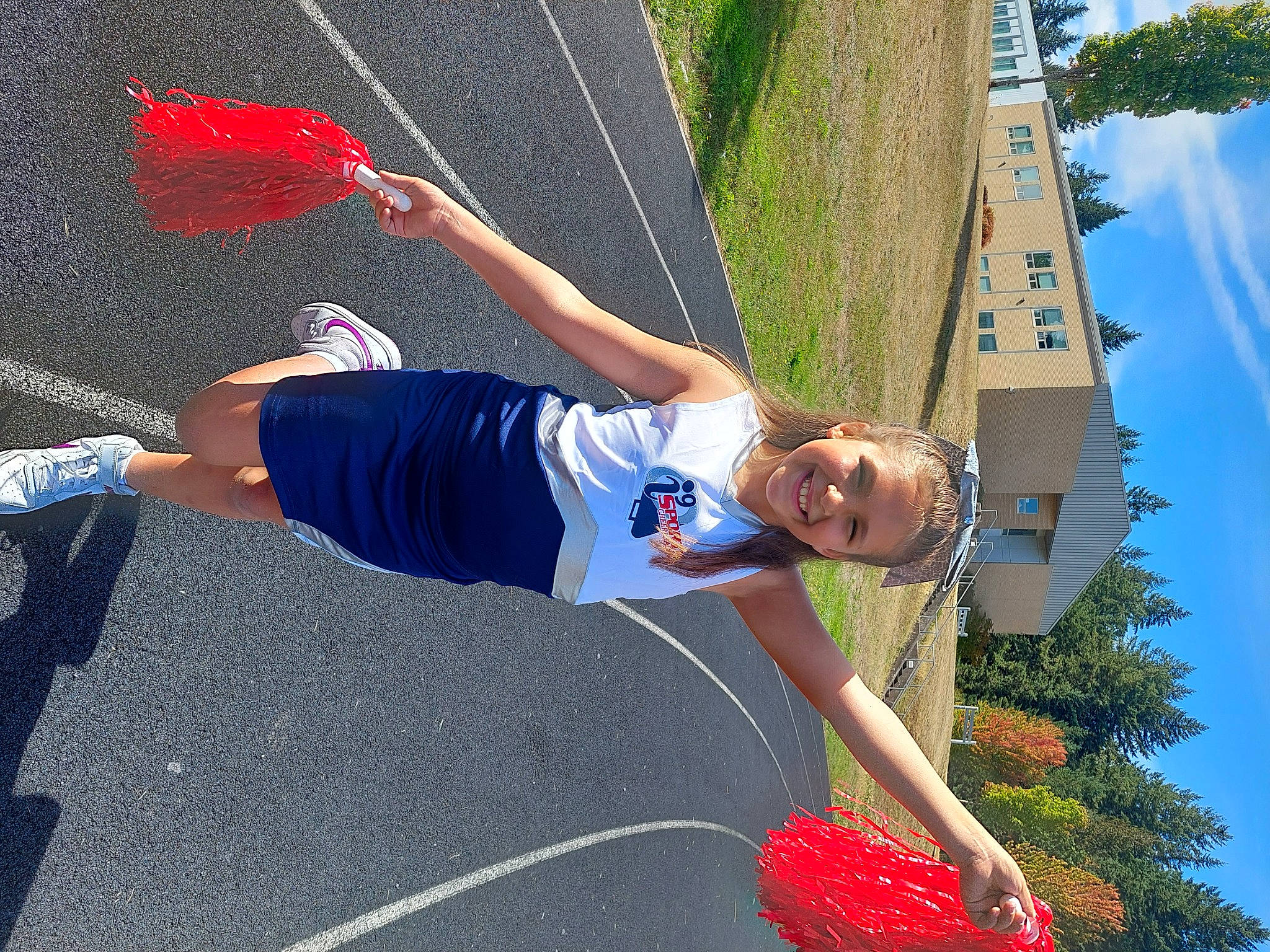 Mya is registered to the contest to win money with this photo: adventure, asphalt, blue, electric_blue, fun, grass, happy, joy, knee, leisure, person, plant, recreation, shorts, sky, smile, sports, sports_uniform, sportswear, summer