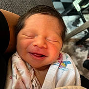 Johana is registered to the contest to win money with this photo: newborn, baby, infant, sleeping, smiling, wrapped, blanket, closeup, person, face, hair, skin, cozy, resting, comfort, indoor, human, cute, peaceful, child