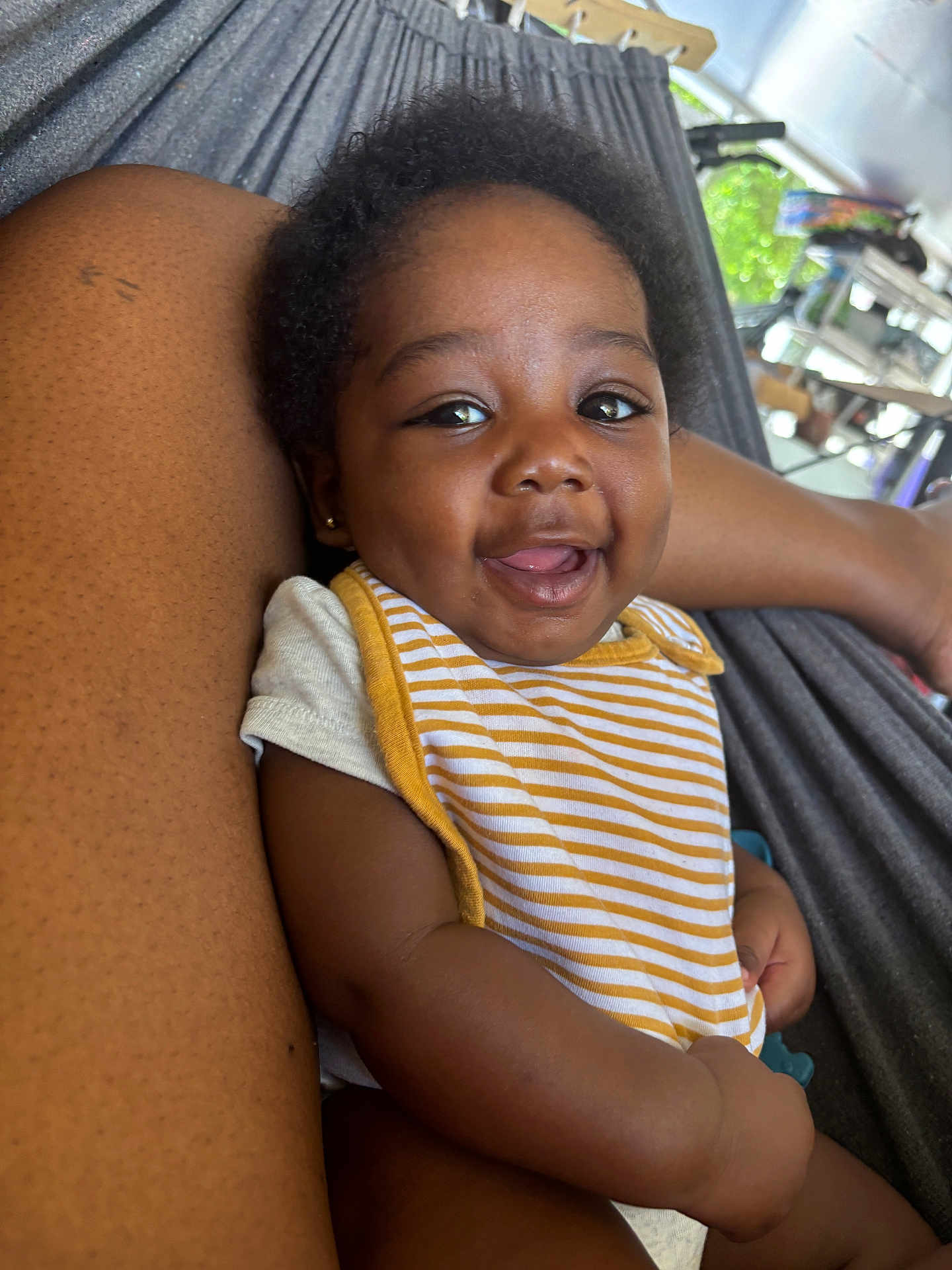 Alexanderisaac is registered to the contest to win money with this photo: baby, smiling, striped_bib, arm, hammock, outdoor, happy, child, skin, person, infant, relaxing, closeup, portrait, cute, young, casual, daylight, comfort, resting