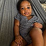 baby, child, infant, hammock, striped_clothing, relaxing, indoor, portrait, cute, face, skin, hand, legs, eyes, smile, person, young_child, comfortable, casual, seated