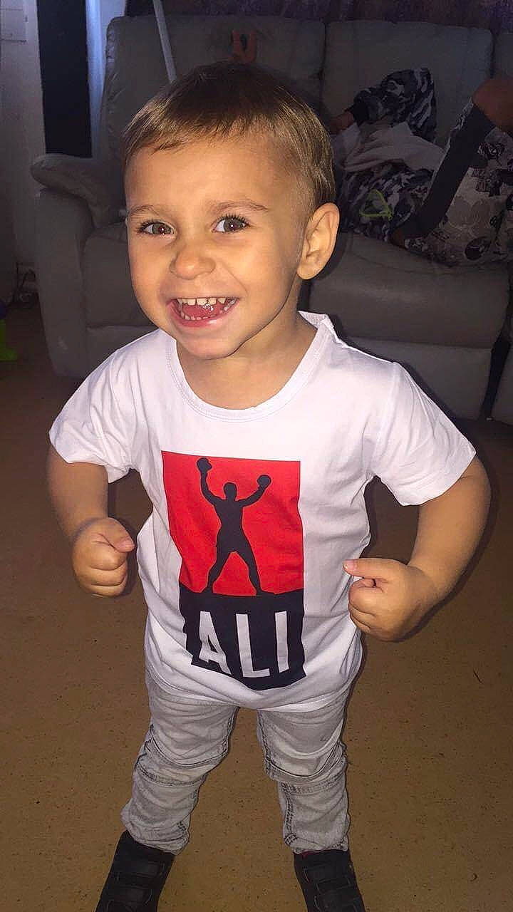 Ali participe au concours pour gagner de l'argent avec cette photo : baby_toddler_clothing, carmine, cheek, child, face, flash_photography, flooring, fun, gesture, happy, head, joint, joy, pattern, person, sleeve, smile, t_shirt, thumb, toddler