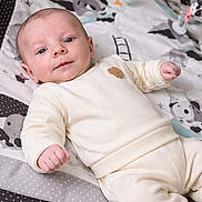 Maël a rejoint le concours — aidez-le/la à gagner de superbes lots ! baby, infant, newborn, onesie, play_mat, toy, lying_down, smiling, face, head, hand, legs, blanket, crib, polka_dot, nursery, soft_toys, indoor, cozy, portrait