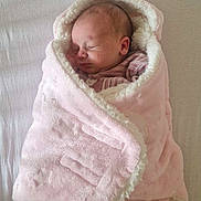 Mencya a rejoint le concours — aidez-le/la à gagner de superbes lots ! baby, newborn, blanket, pink, sleeping, wrapped, cozy, soft, infant, face, child, bed, fabric, cute, peaceful, indoor, portrait, rest, person, toddler