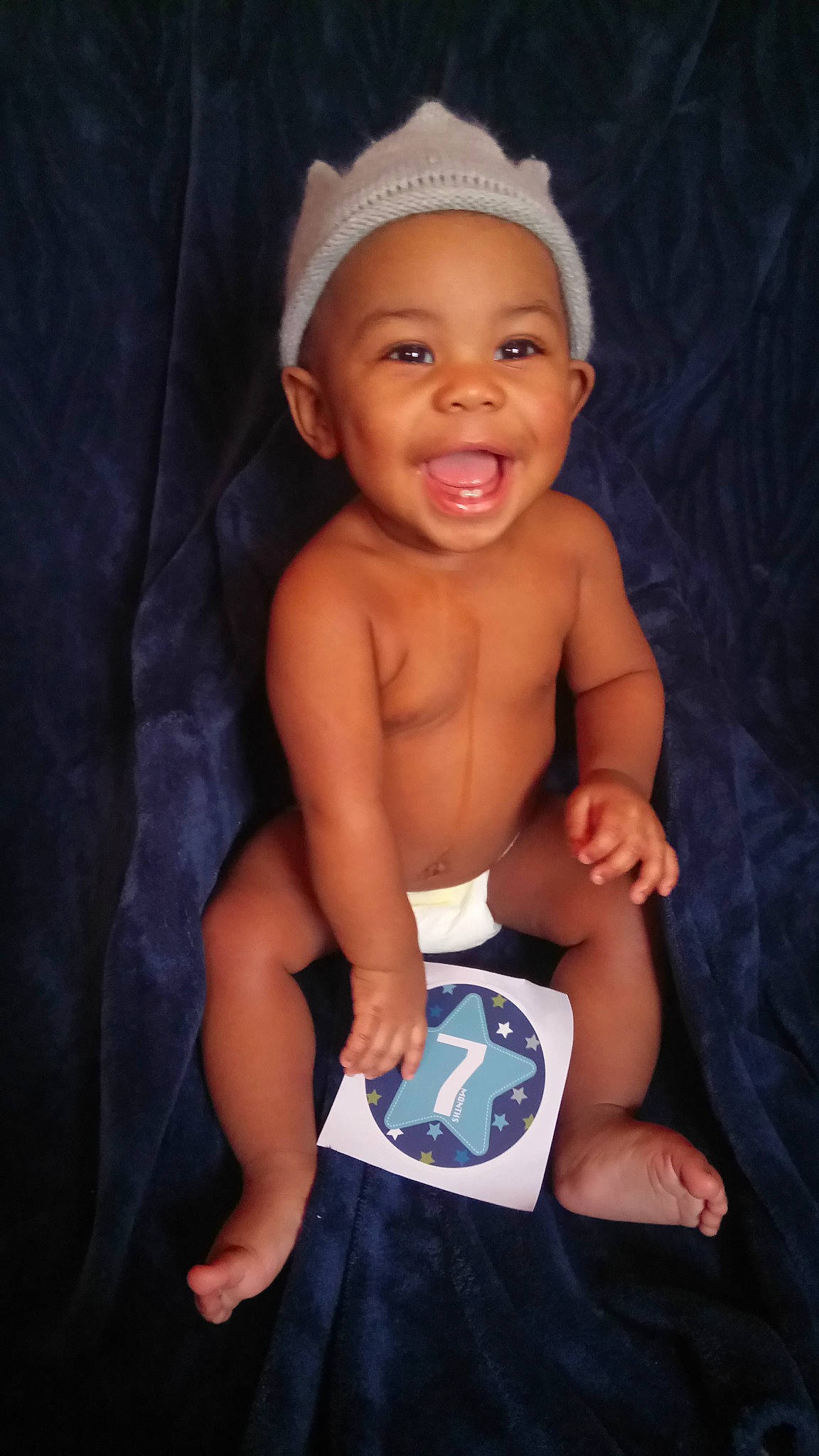 Jeremiah is registered to the contest to win money with this photo: arm, baby, child, head, headgear, muscle, person, product, sitting, smile, toddler