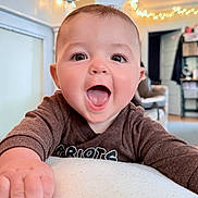 Beau joined the competition — help win amazing prizes! baby, child, smiling, happy, indoor, face, person, clothing, hand, expression, cute, infant, tongue, eyes, light, string_lights, background, furniture, home, cozy