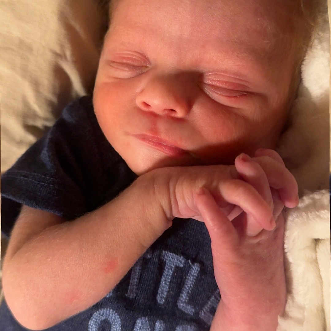 Calvin is registered to the contest to win money with this photo: baby, bed, bedroom, blanket, bodypart, clothing, cushion, face, finger, furniture, hand, head, indoors, newborn, person, photography, portrait, room, sleeping, t_shirt