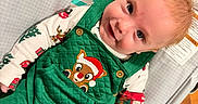 Carter joined the competition — help win amazing prizes! baby, child, infant, green_overalls, reindeer_patch, festive_clothing, play_mat, cartoon_animals, elephant, monkey, wooden_floor, smiling, lying_down, cute, indoors, person, colorful, happy, soft_texture, holiday