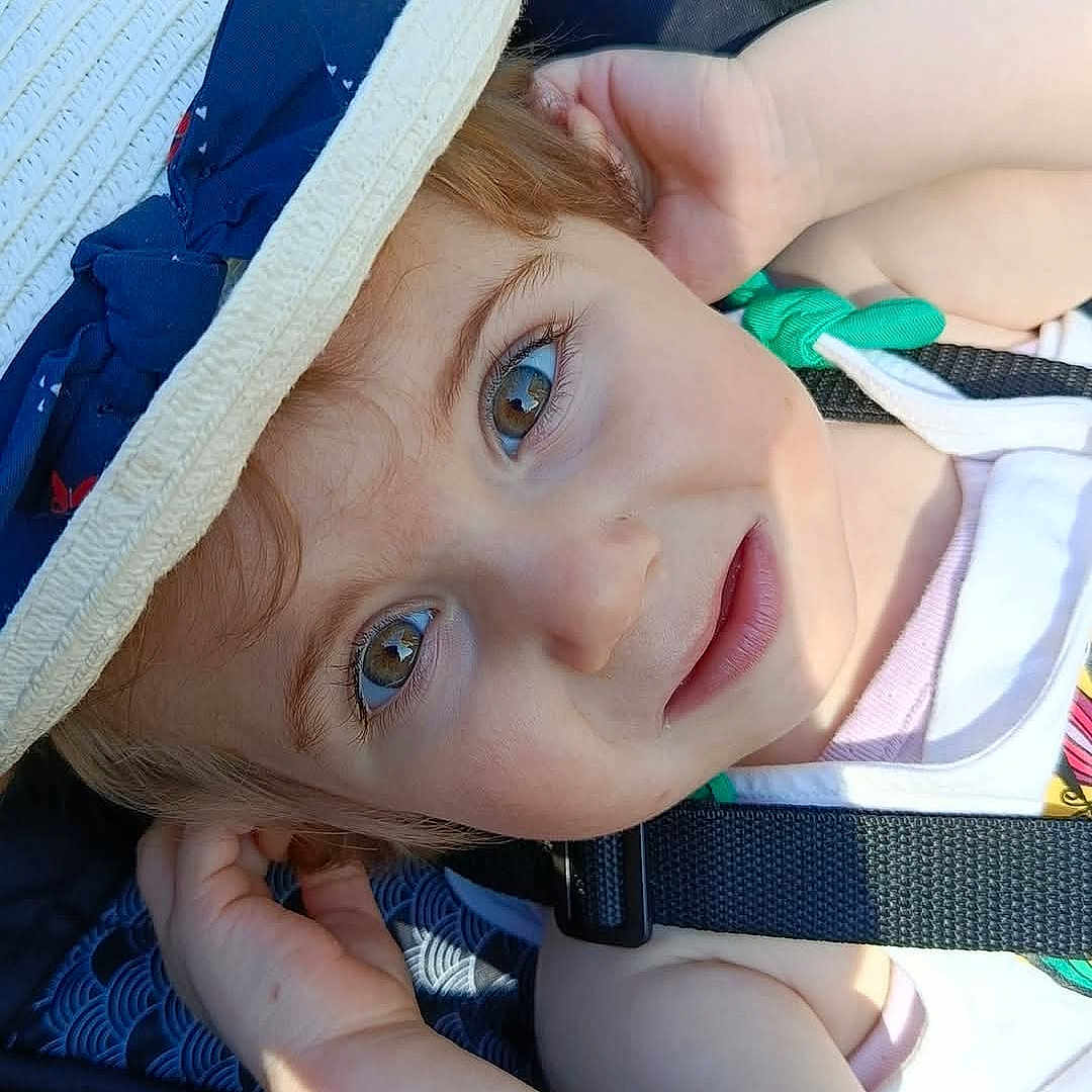 Eve a rejoint le concours — aidez-le/la à gagner de superbes lots ! arm, baby, child, closeup, clothing, curly_hair, cute, eyes, face, hand, hat, outdoor, portrait, relaxing, seatbelt, skin, smile, stroller, sunlight, toddler
