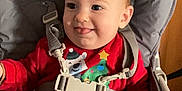 Fabio a rejoint le concours — aidez-le/la à gagner de superbes lots ! baby, infant, high_chair, safety_harness, buckle, holiday_sweater, christmas_tree, tongue_out, smile, face, eyes, hair, cheek, ear, plastic_tray, seat, indoor, wooden_background, portrait, cute
