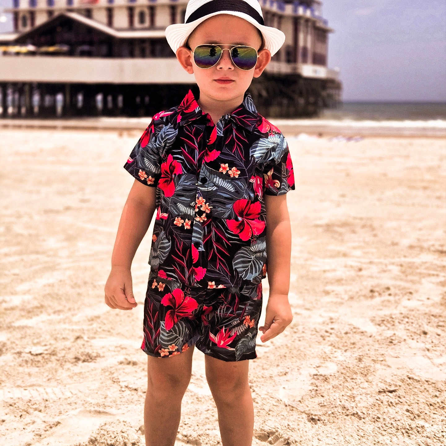 Noah is registered to the contest to win money with this photo: beach, boy, casual, child, confident, floral_pattern, footwear, hat, ocean, outdoor, pier, reflection, sand, shirt, shorts, standing, summer, sunglasses, sunny, vacation