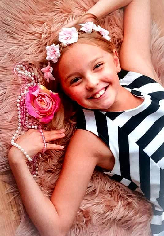 Athelia a rejoint le concours — aidez-le/la à gagner de superbes lots ! bridal_clothing, child, dress, facial_expression, finger, flash_photography, flower, formal_wear, gesture, gown, hair, happy, headgear, headpiece, joy, person, petal, pink, plant, skin