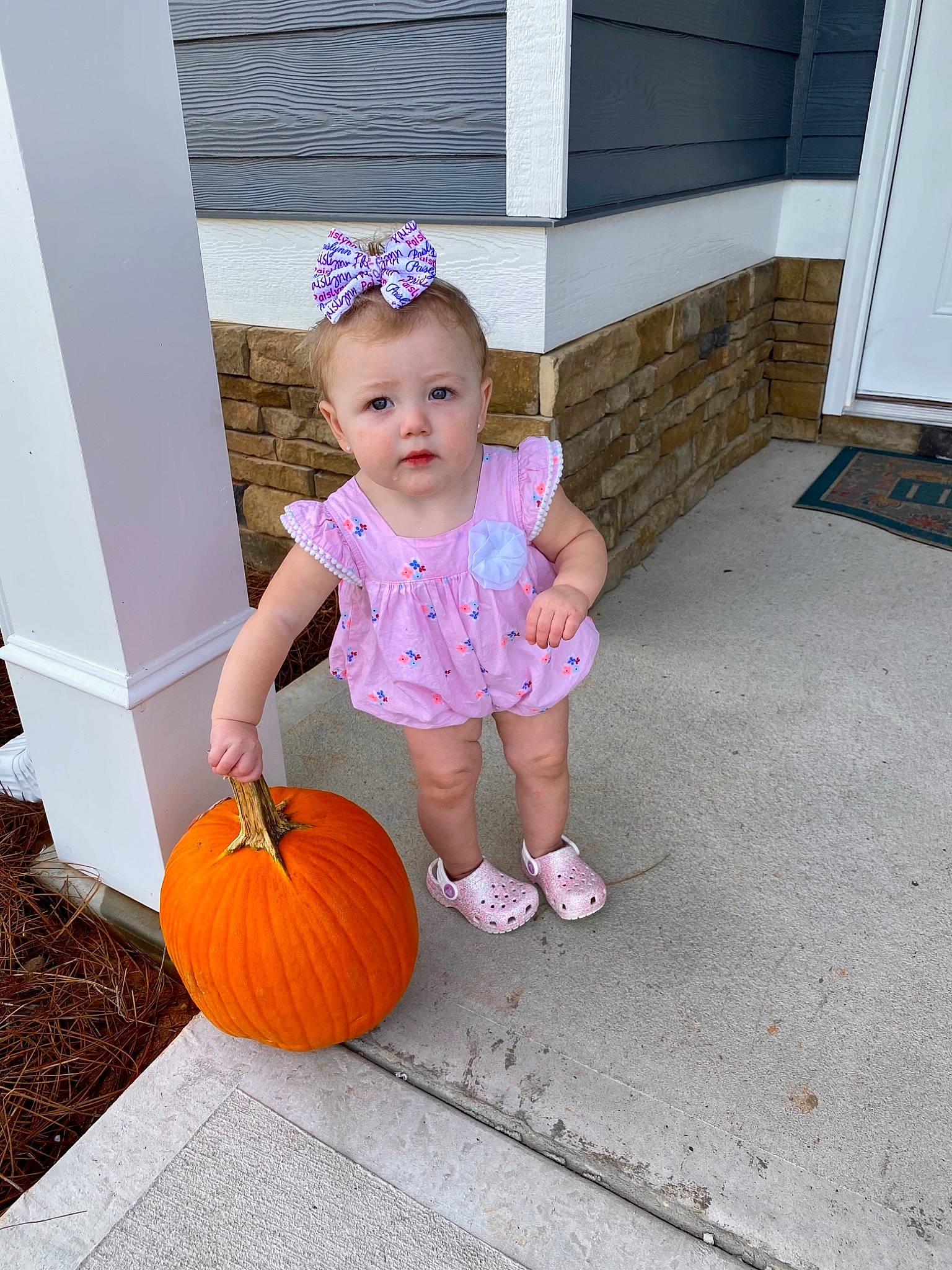 Paislynn joined the competition — help win amazing prizes! baby_toddler_clothing, calabaza, child, cucurbita, door, dress, floor, flooring, fun, gourd, happy, hat, natural_foods, person, plant, pumpkin, shorts, squash, toddler, vegetable