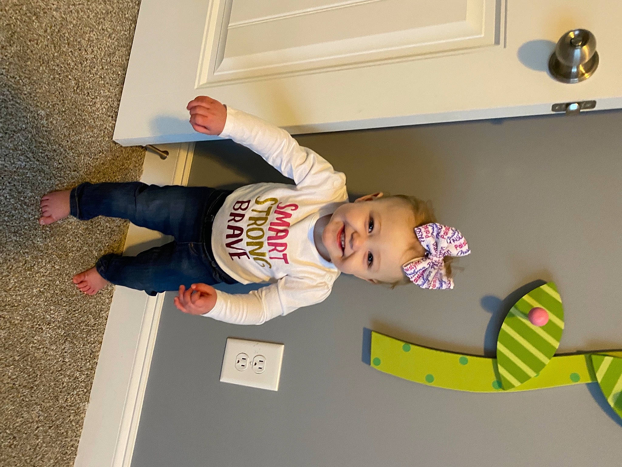 Paislynn is registered to the contest to win money with this photo: baby, child, floor, flooring, fun, hat, home_appliance, house, joy, lamp, leg, light_fixture, person, room, smile, sneakers, toddler, toy, walking_shoe, wood