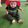 Lakoda joined the competition — help win amazing prizes! baby, child, hat, bib, green_carpet, sitting, indoor, person, curious, smile, legs, furniture, couch, clothing, foot, headwear, infant, cute, bright_colors, casual