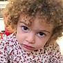 child, toddler, curly_hair, blue_eyes, floral_shirt, portrait, face, looking, indoor, cute, young, person, closeup, expression, innocent, curious, clothing, head, skin, baby